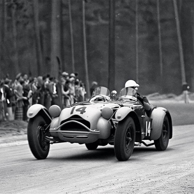 Vintage racing car on a track with spectators in the background