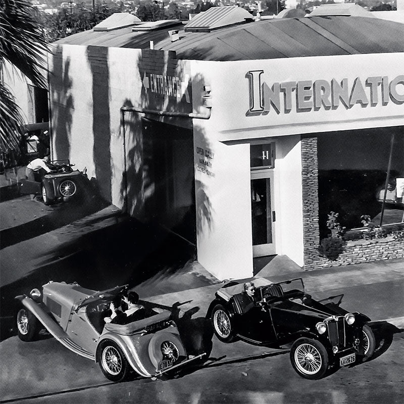 Vintage cars parked in front of a building with 'International' branding.
